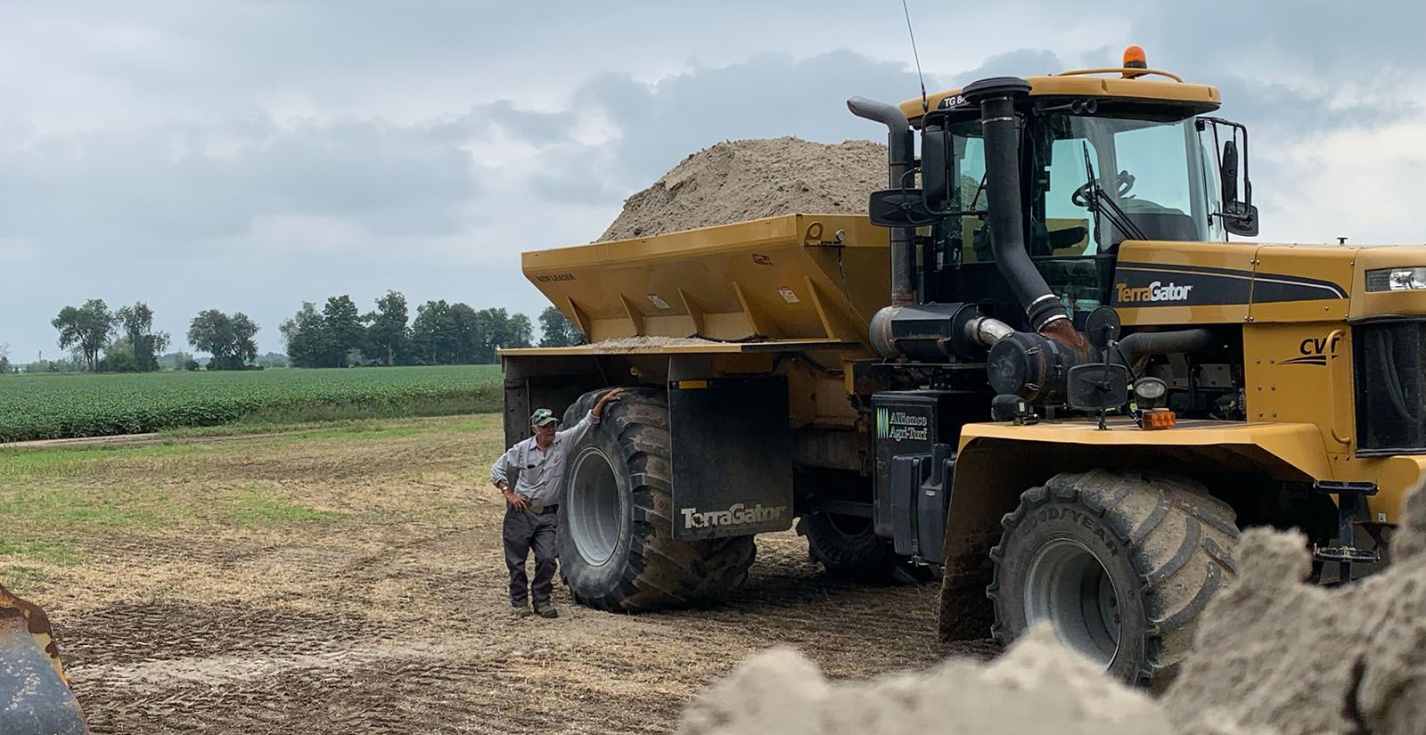 Alliance Agri-Turf employee standing beside agricultural equipment