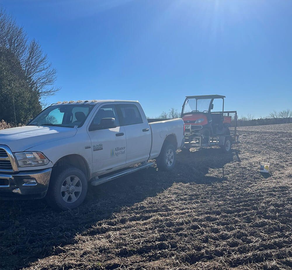 Alliance Agri-Turf agricultural equipment and truck with blue skies